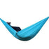 Person lounging in a light blue nylon hammock with relaxed fit and casual outdoor style