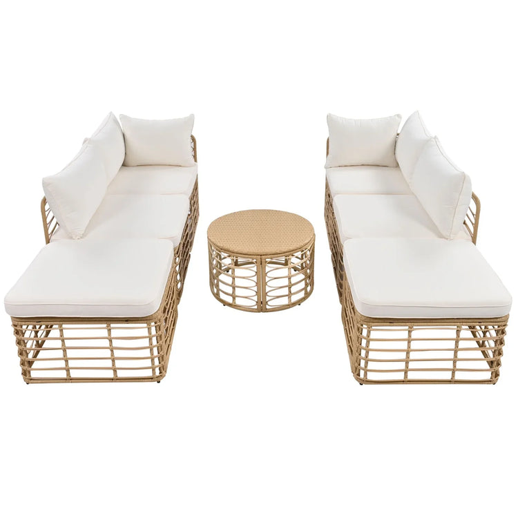 Beige rattan outdoor lounge set with white cushions and round wicker coffee table