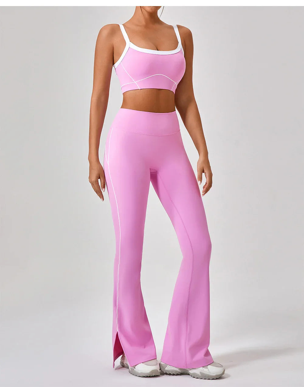 Woman wearing pink fitted sports bra and high-waisted flared leggings with white trim