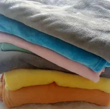 Stack of soft fleece streetwear sweatshirts in gray, blue, pink, yellow, and orange colors