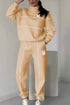 Woman wearing a beige oversized tracksuit with white piping and relaxed fit.