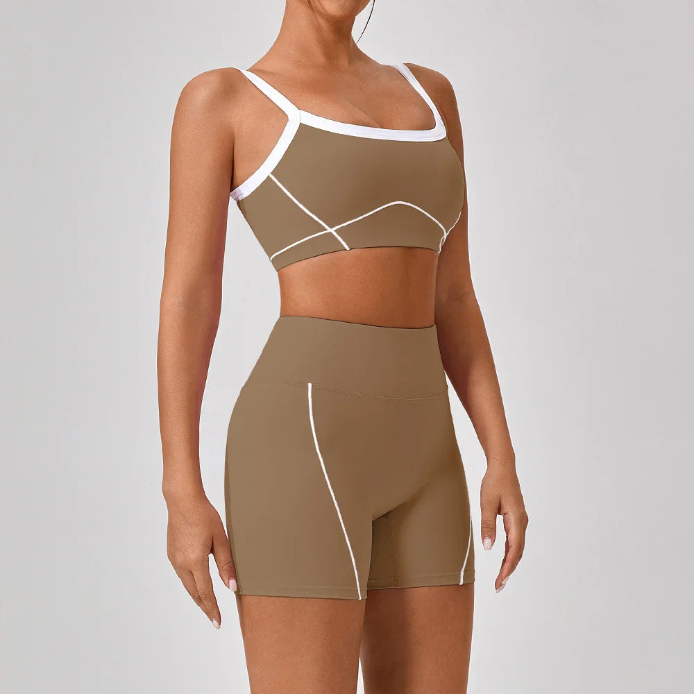 Woman wearing fitted brown athletic shorts and sports bra with white trim and stitching.