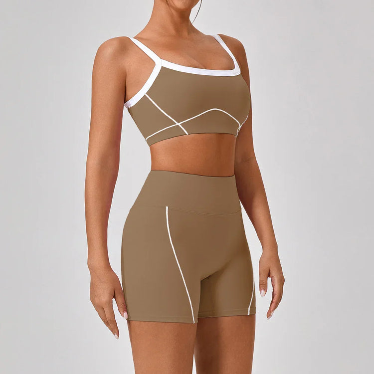 Woman wearing fitted brown athletic shorts and sports bra with white trim and stitching.