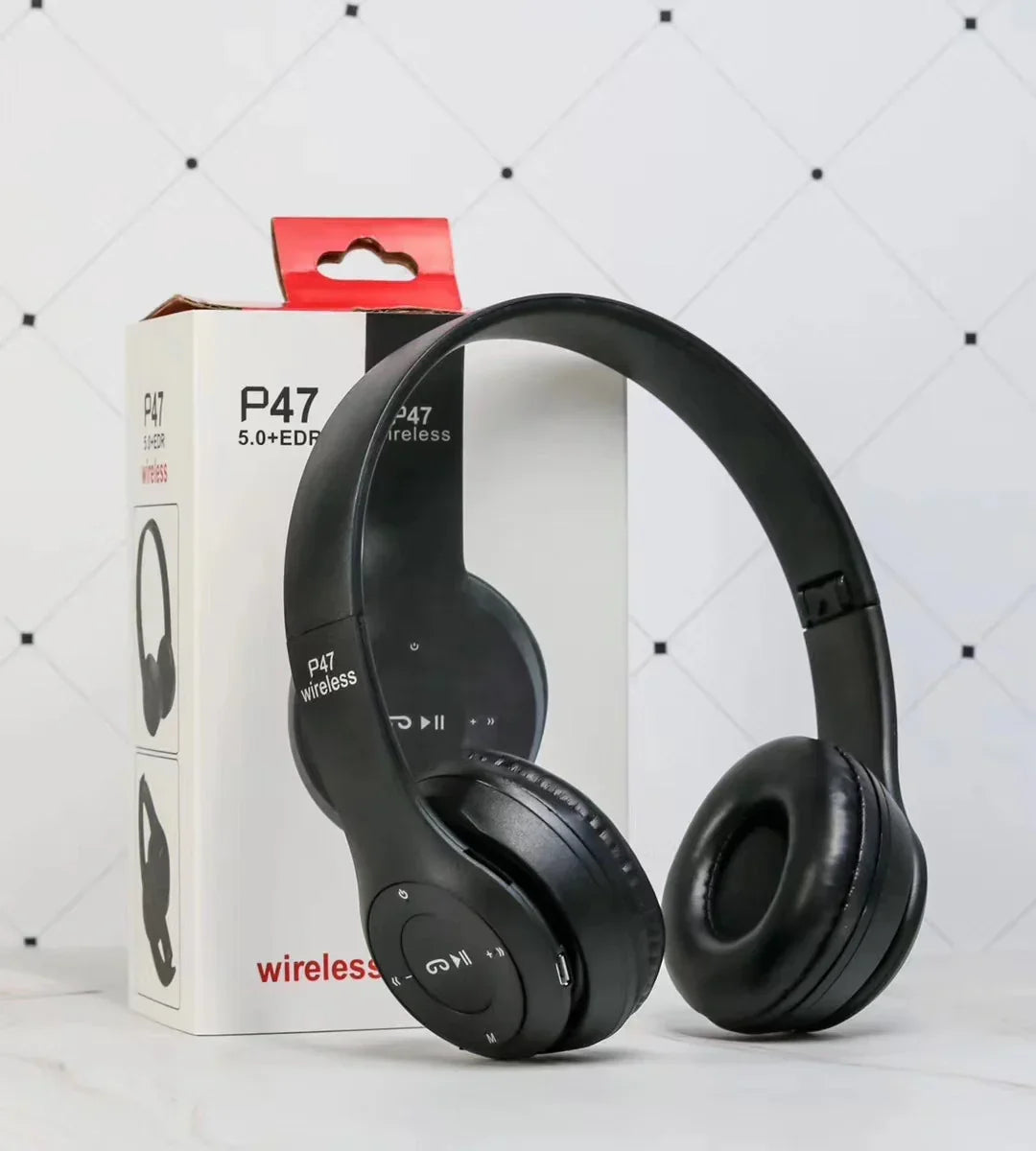Black over-ear wireless headphones with cushioned ear pads and control buttons, displayed with box
