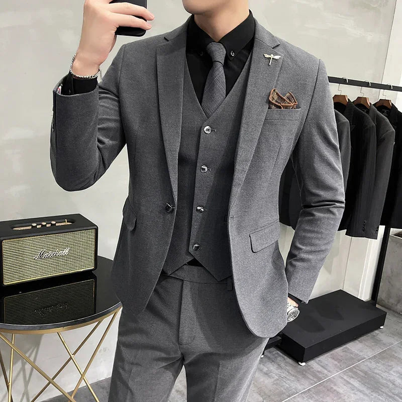 Slim fit gray suit with matching vest, black shirt and tie, modern formal wear style