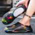 Black slip-on foam clogs with colorful paint splatter design, round toe, and cushioned fit.