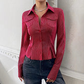 Fitted red pinstripe long-sleeve shirt with pointed collar and chest pockets, styled with dark jeans