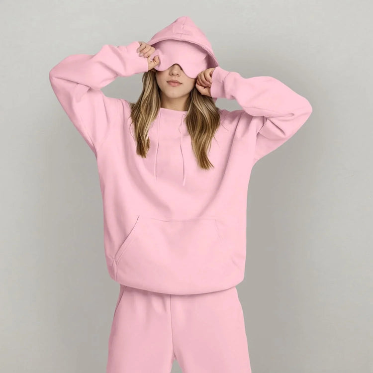 Woman in oversized light pink hoodie and matching sweatpants, soft cotton, relaxed fit