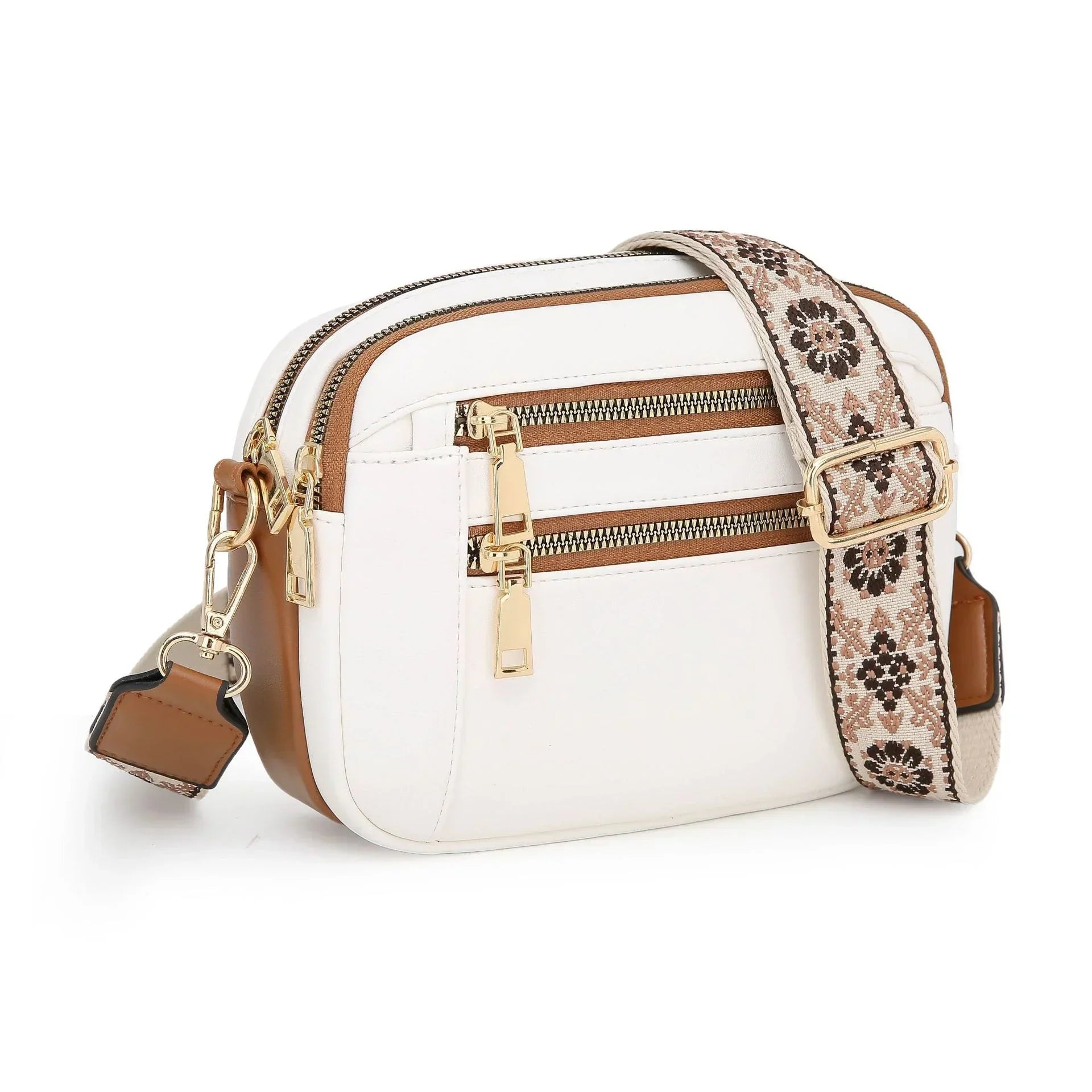 White and tan faux leather crossbody bag with gold zippers and a wide floral woven strap