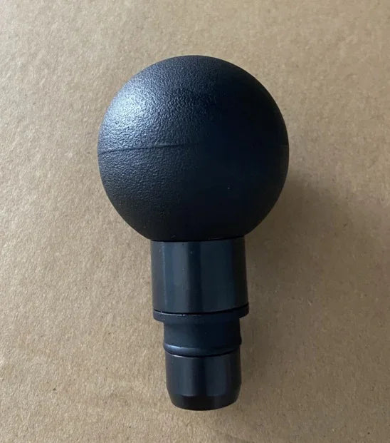 Black round plastic massage gun attachment on a plain background