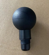 Black round plastic massage gun attachment on a plain background