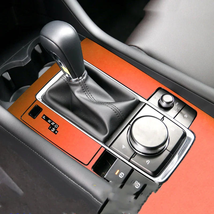 Modern car center console with black leather gear shift, orange panel, and chrome accents