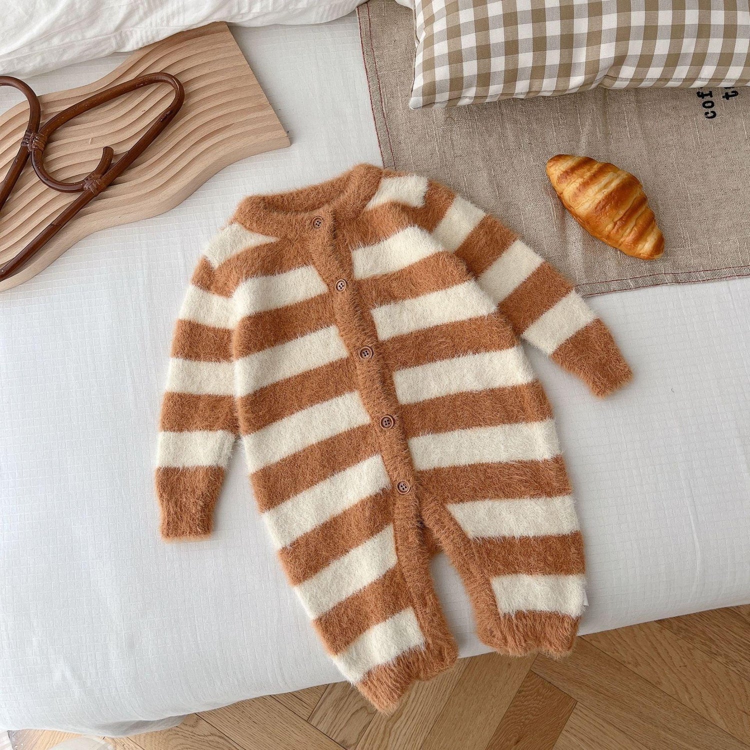 Soft fuzzy brown and white striped baby jumpsuit with buttons, long sleeves, and relaxed fit