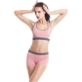 Woman wearing pink seamless sports bra and shorts set with grey trim, fitted athletic wear