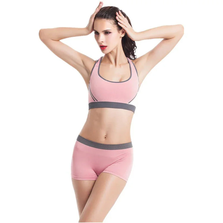 Woman wearing pink seamless sports bra and shorts set with grey trim, fitted athletic wear