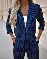 Woman wearing navy blue pinstripe suit with cropped blazer and relaxed fit pants