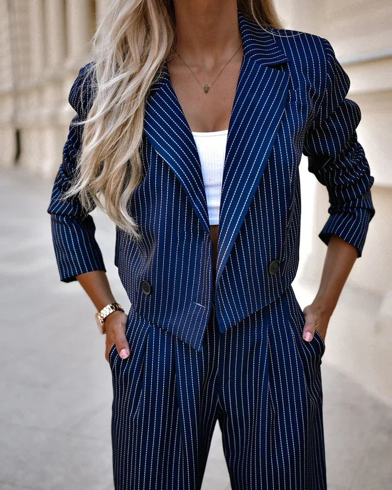 Woman wearing navy blue pinstripe suit with cropped blazer and relaxed fit pants