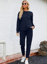 Woman wearing black long sleeve sweatshirt and jogger pants set, relaxed fit, casual streetwear style