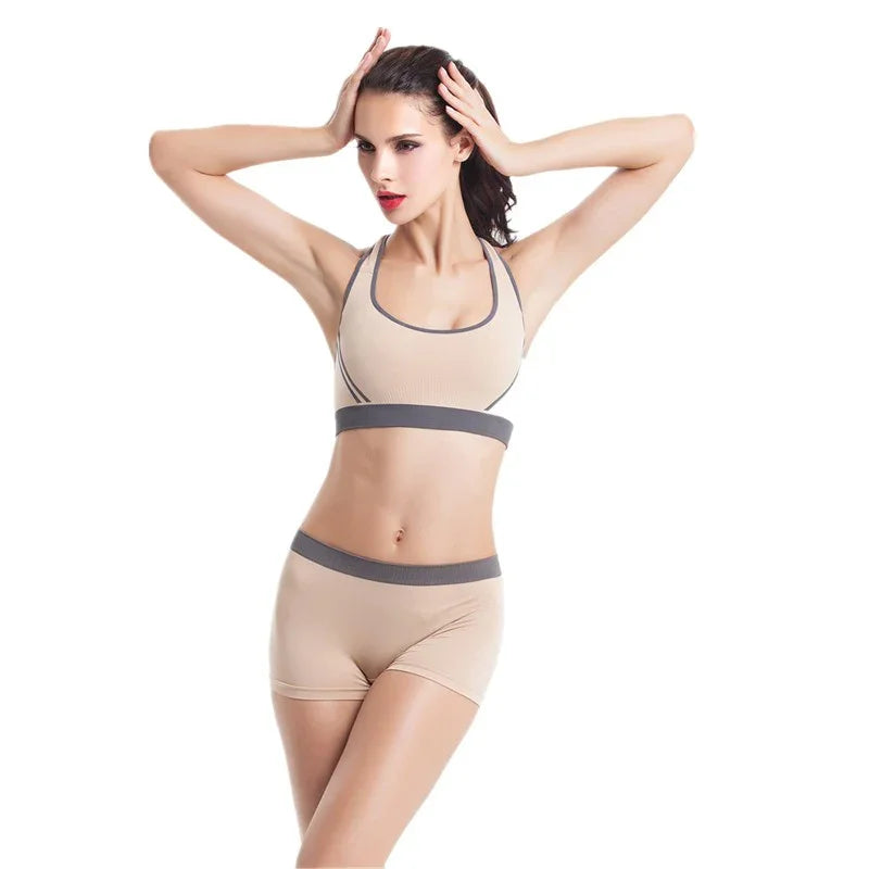 Woman modeling beige seamless sports bra and shorts set with gray trim, fitted and sporty style