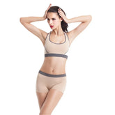 Woman modeling beige seamless sports bra and shorts set with gray trim, fitted and sporty style