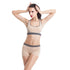 Woman modeling beige seamless sports bra and shorts set with gray trim, fitted and sporty style