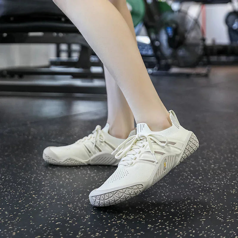 Beige knit athletic sneakers with textured rubber sole, worn in gym, slim fit design