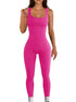 Woman wearing a fitted hot pink ribbed sleeveless jumpsuit, stretchy material, scoop neckline.