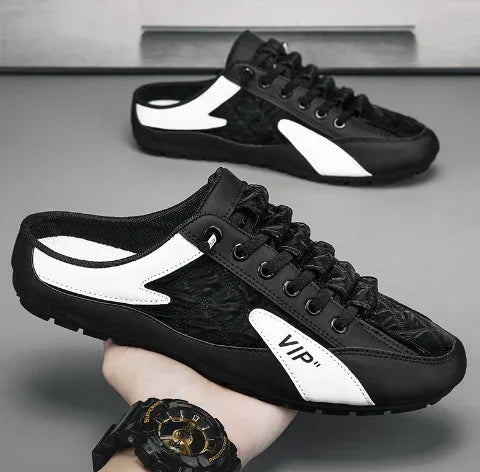 Black and white slip-on sneakers with mesh upper, low-profile fit, and lace-up design