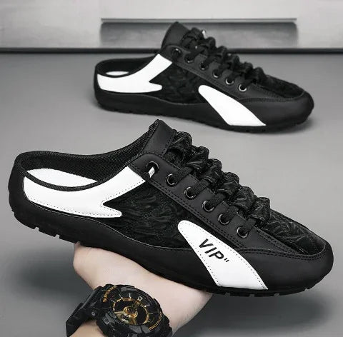 Black and white slip-on sneakers with mesh upper, low-profile fit, and lace-up design