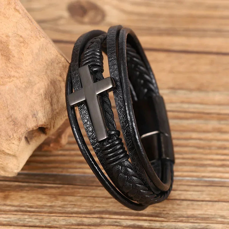 Black leather multi-strand bracelet with metal cross and adjustable fit on wood surface