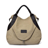 Beige canvas tote bag with black faux leather handles and trim, modern oversized fit