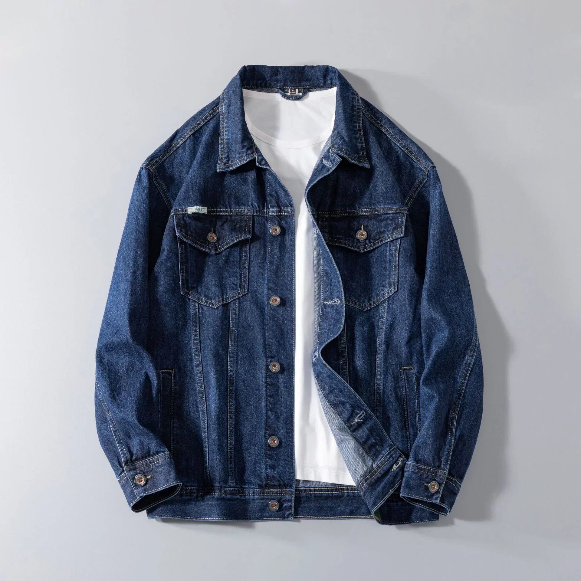 Dark blue denim jacket with button closure and chest pockets, layered over a white t-shirt