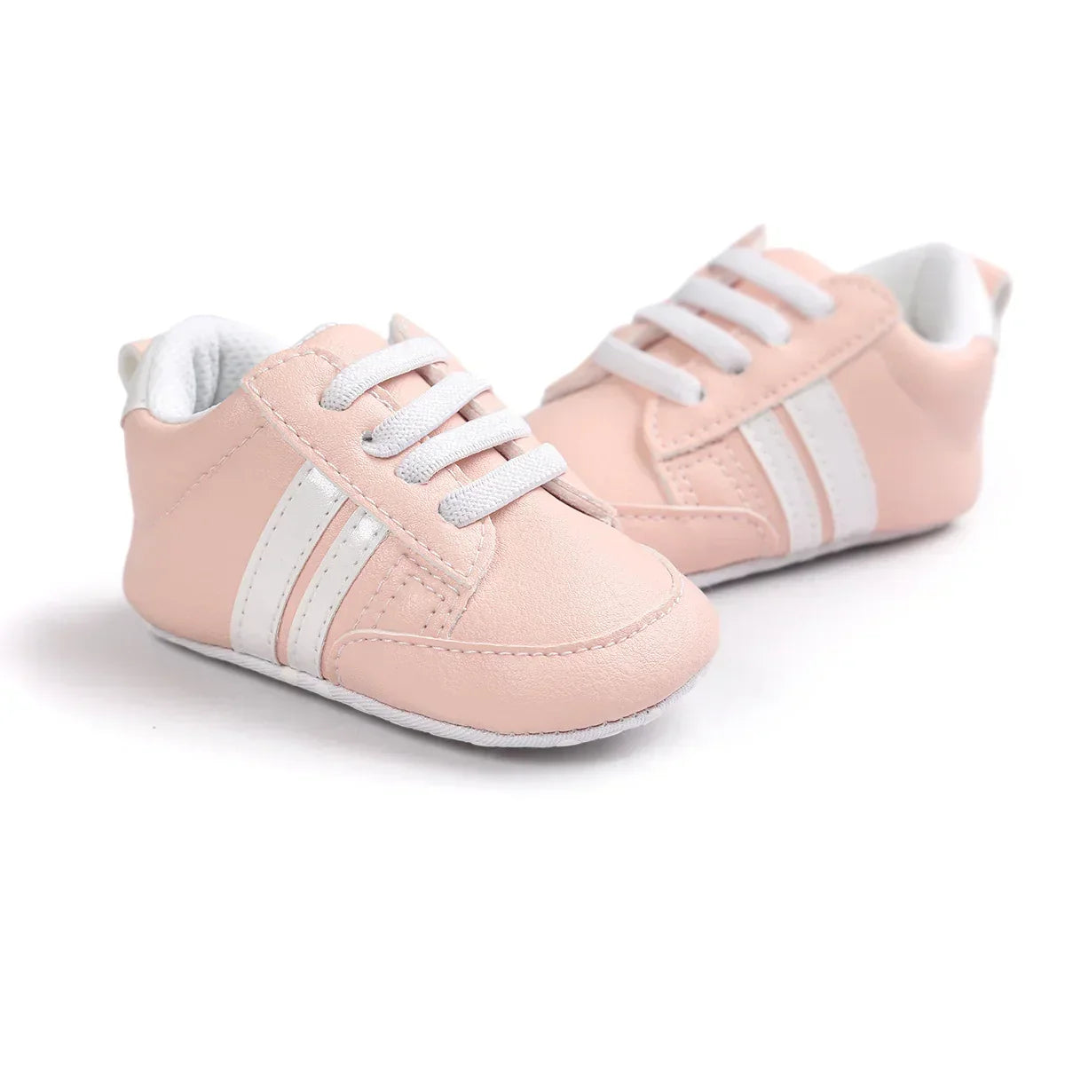 Light pink faux leather baby sneakers with white stripes and laces, soft sole design