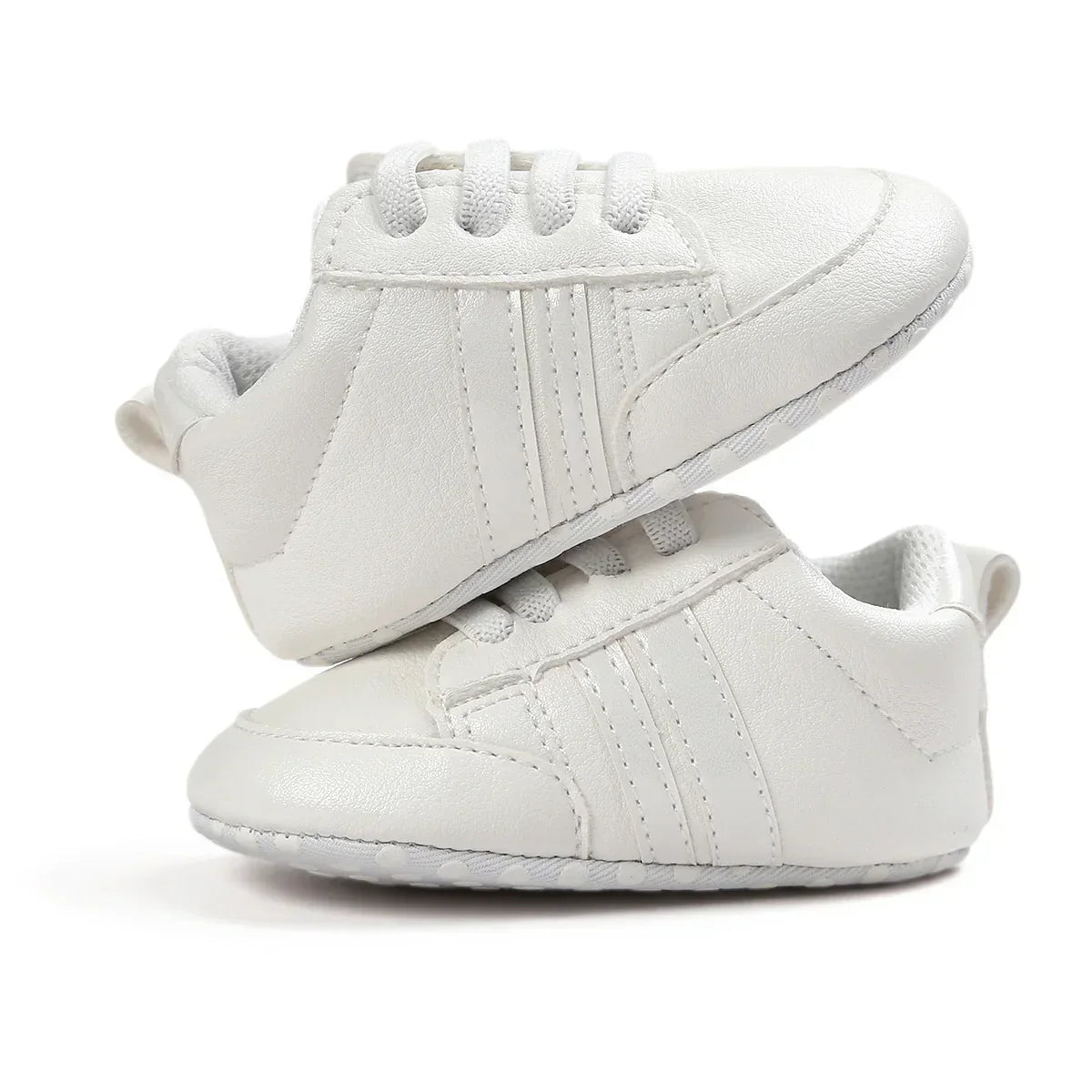 White faux leather baby sneakers with lace-up design and soft sole, minimalist style