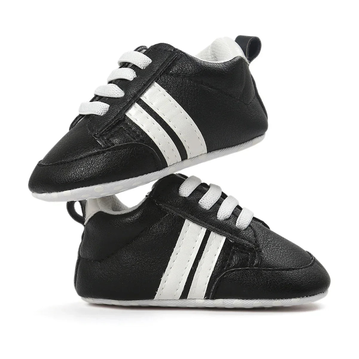 Black faux leather baby sneakers with white stripes and laces, sporty design, soft sole