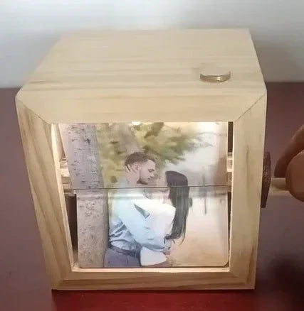 Wooden photo box with rotating handle, displaying a romantic couple's photo inside.