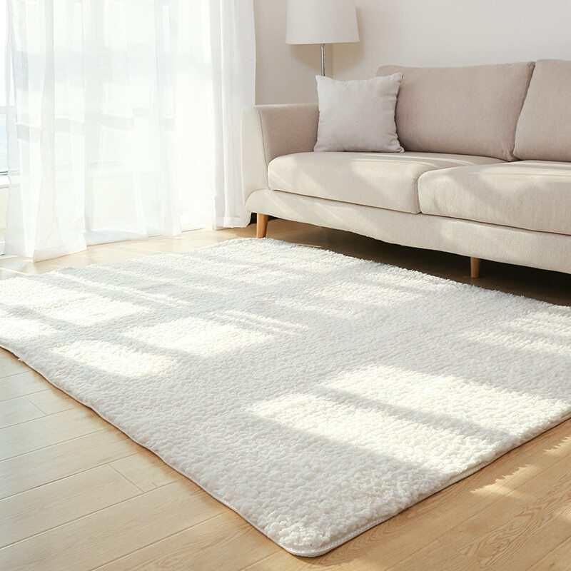 Modern living room with beige fabric sofa, fluffy white area rug, and light wood flooring