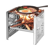 Stainless steel portable camp stove with wood fire, cooking breakfast in skillet