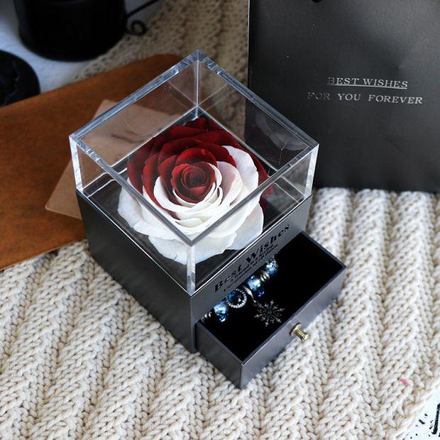 Red and white preserved rose in clear acrylic box with a small black jewelry drawer