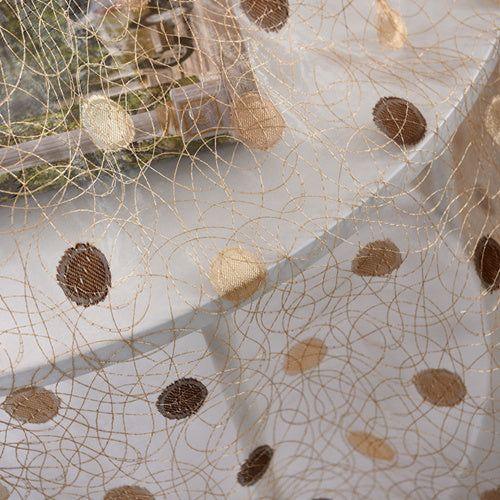 Sheer mesh fabric with gold embroidered swirls and brown polka dots, lightweight texture