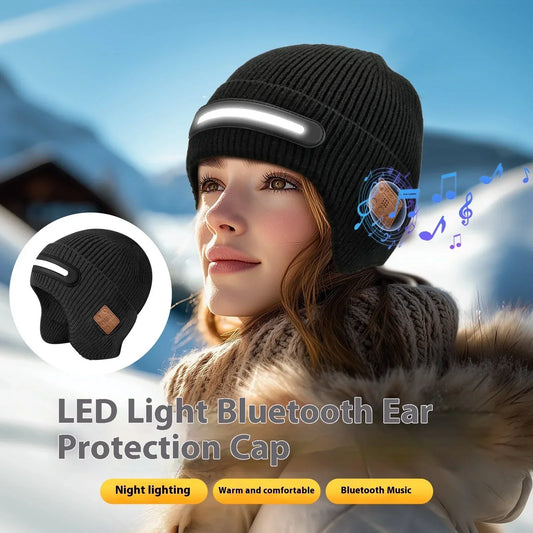 Woman wearing a black knit beanie with LED light and Bluetooth headphones in snowy outdoor setting