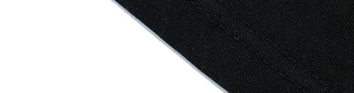 Close-up of black cotton streetwear fabric with visible stitching and clean seam
