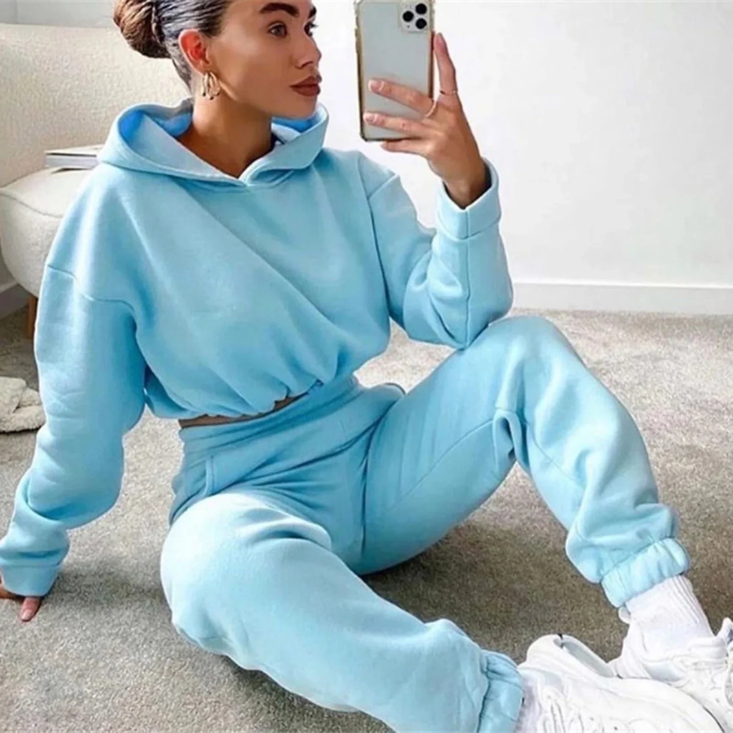 Woman in light blue oversized fleece hoodie and jogger sweatpants set, relaxed fit, casual streetwear style.