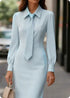 Woman wearing light blue long-sleeve fitted dress with matching tie, street style fashion.