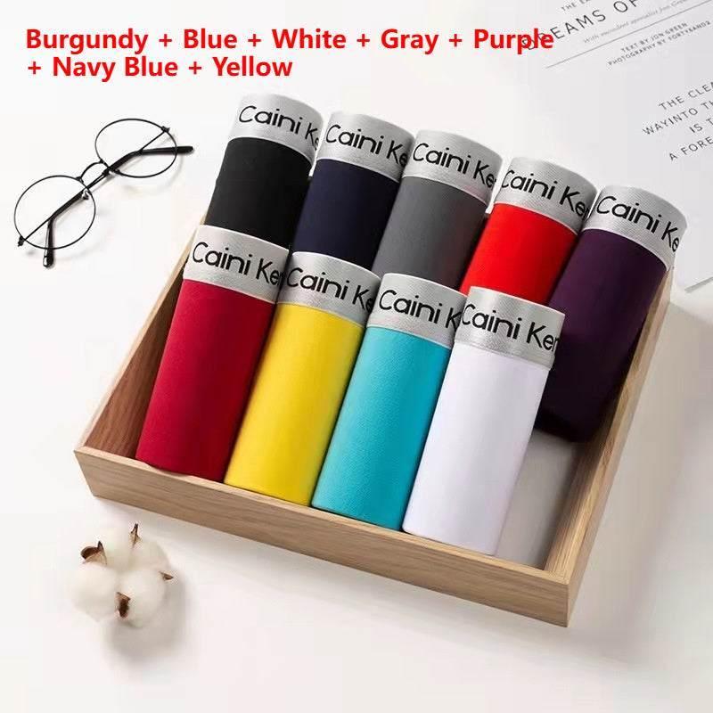 Set of colorful cotton crew socks neatly rolled in a wooden box, various solid colors.