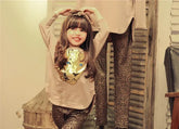 Girl in beige long-sleeve top with gold sequin tiger design and leopard print leggings