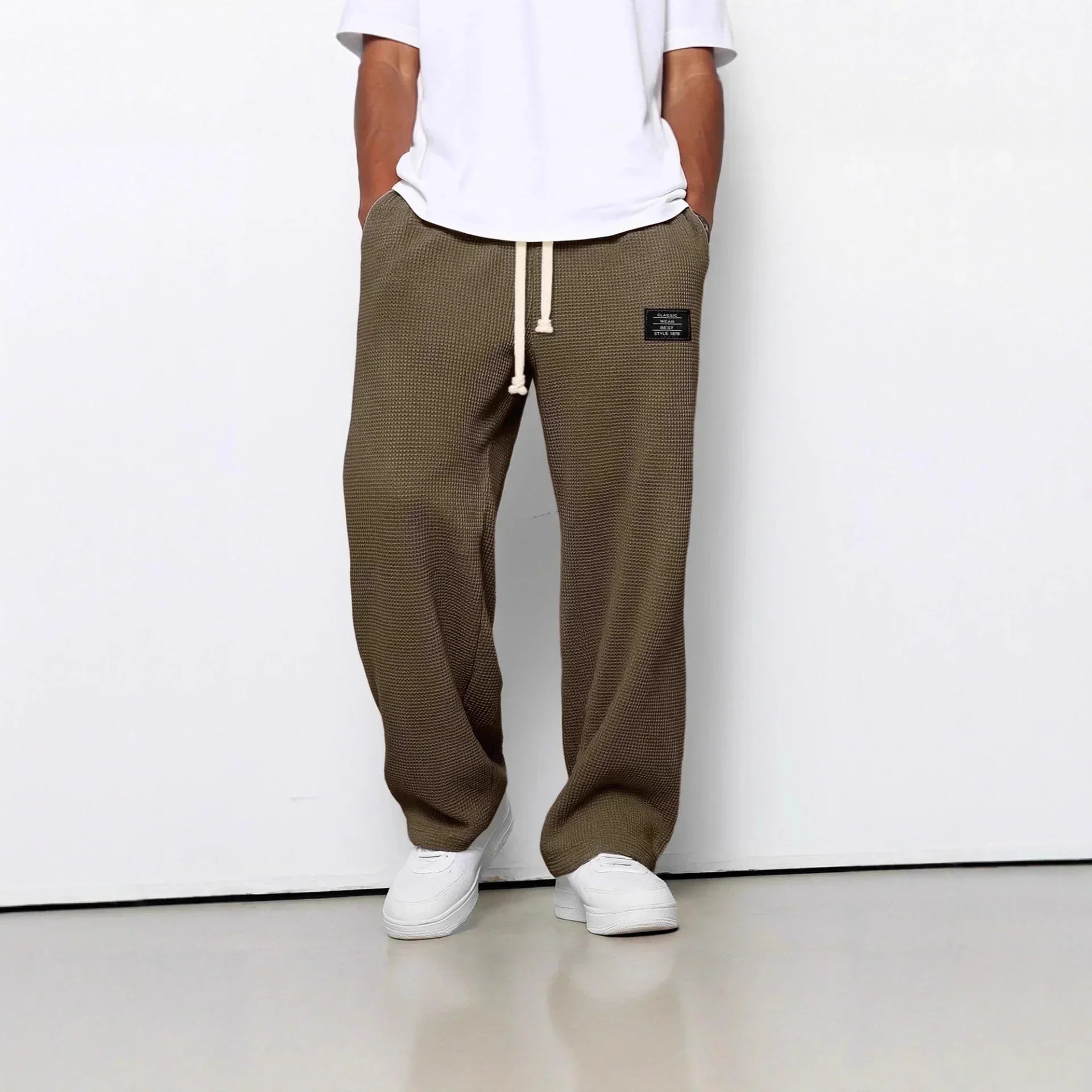 Relaxed fit brown textured pants with drawstring waist, paired with white sneakers