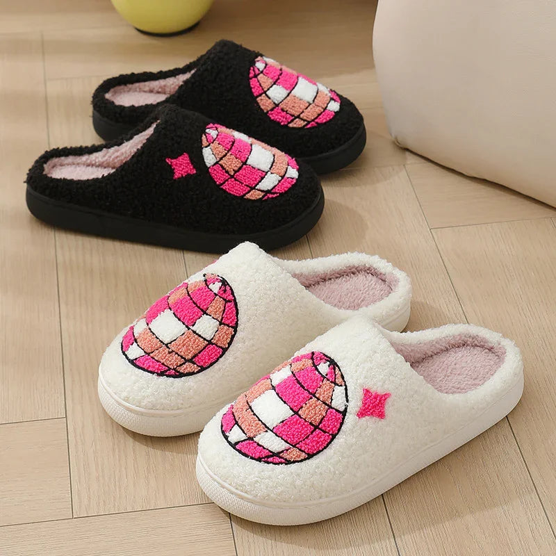 Cozy slip-on slippers in black and white with textured pink embroidered globe design, fleece material, indoor casual fit