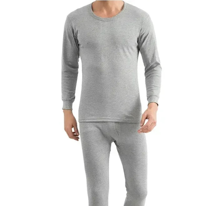 Man wearing grey long sleeve thermal underwear set, minimalist design, plain background