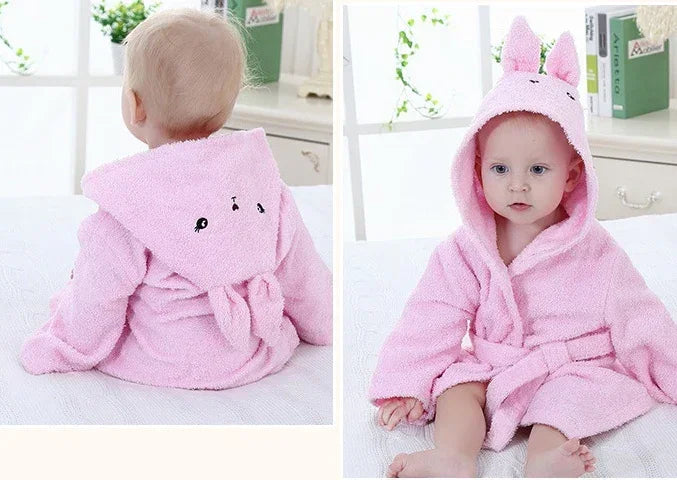 Baby wearing a soft pink hooded robe with bunny ears and a tie waist, cozy fit.